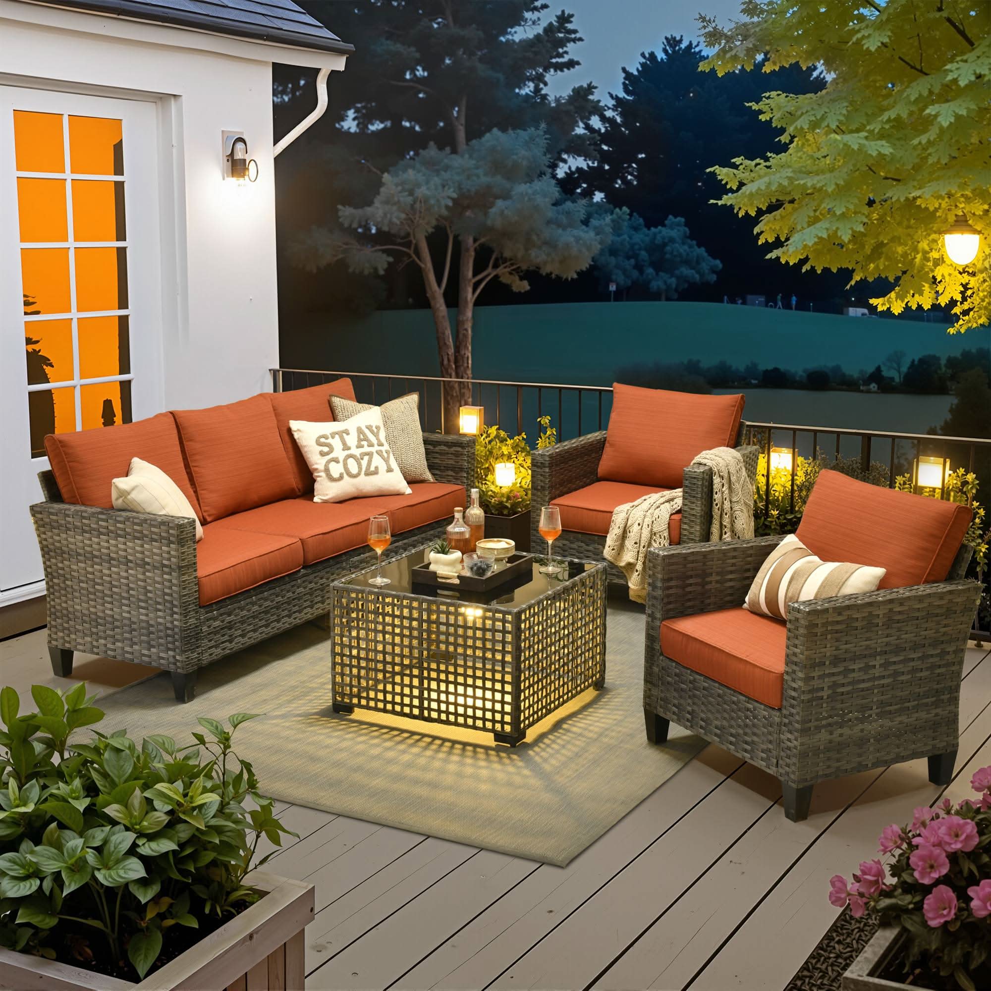 Orange |OVIOS 4-piece wicker patio conversation set with orange cushions and illuminated solar table at twilight.