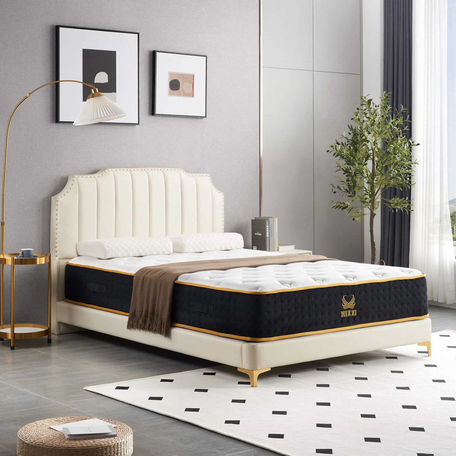 An Ovios cream tufted bed frame holds a premium black and gold mattress, accented by a modern arch floor lamp
