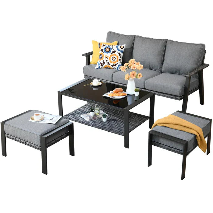 Ovios patio set features a three-seat grey sofa, two ottomans, and a black glass-top coffee table with woven details