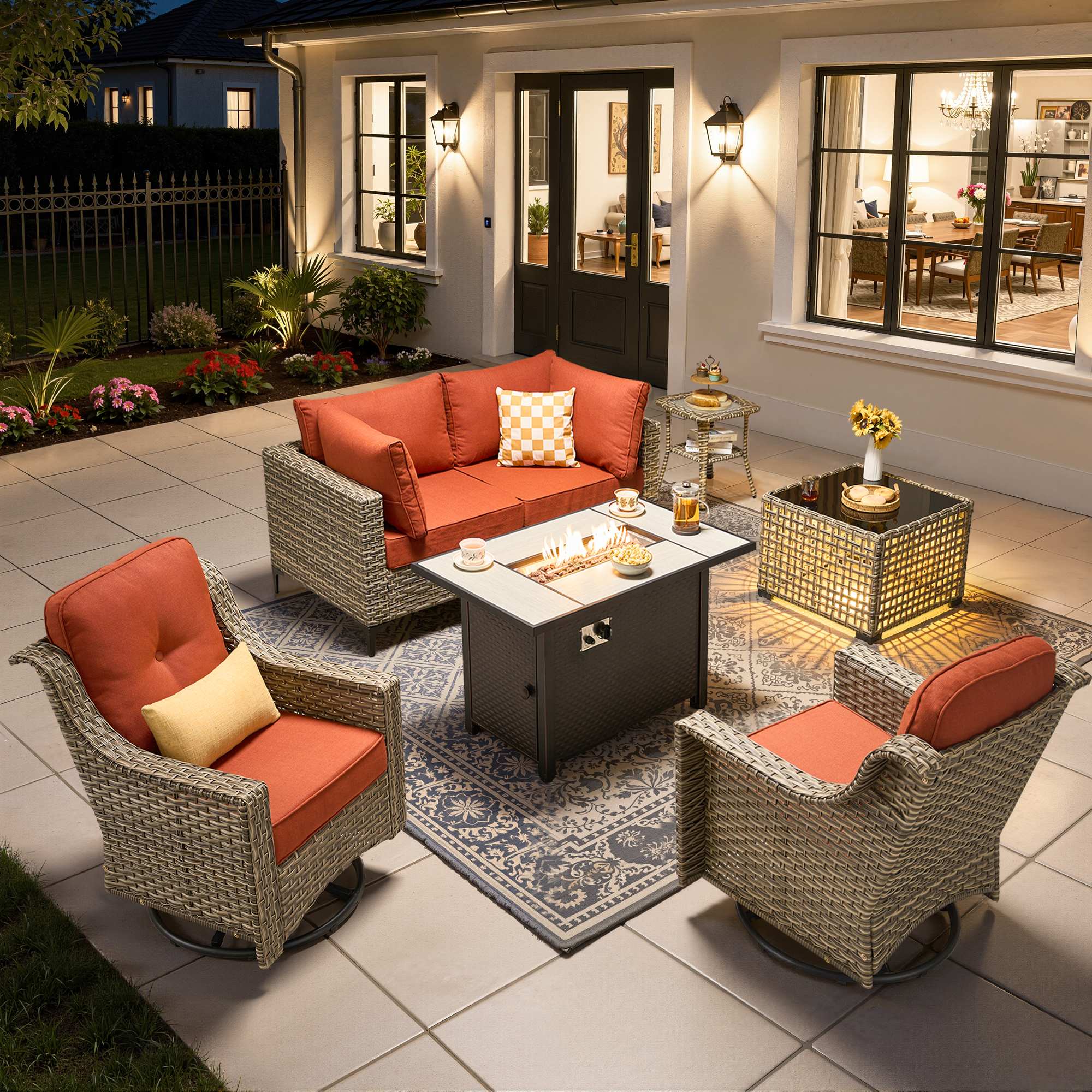 OVIOS wicker patio conversation set: modular sectional, fire pit table, orange swivel chairs.