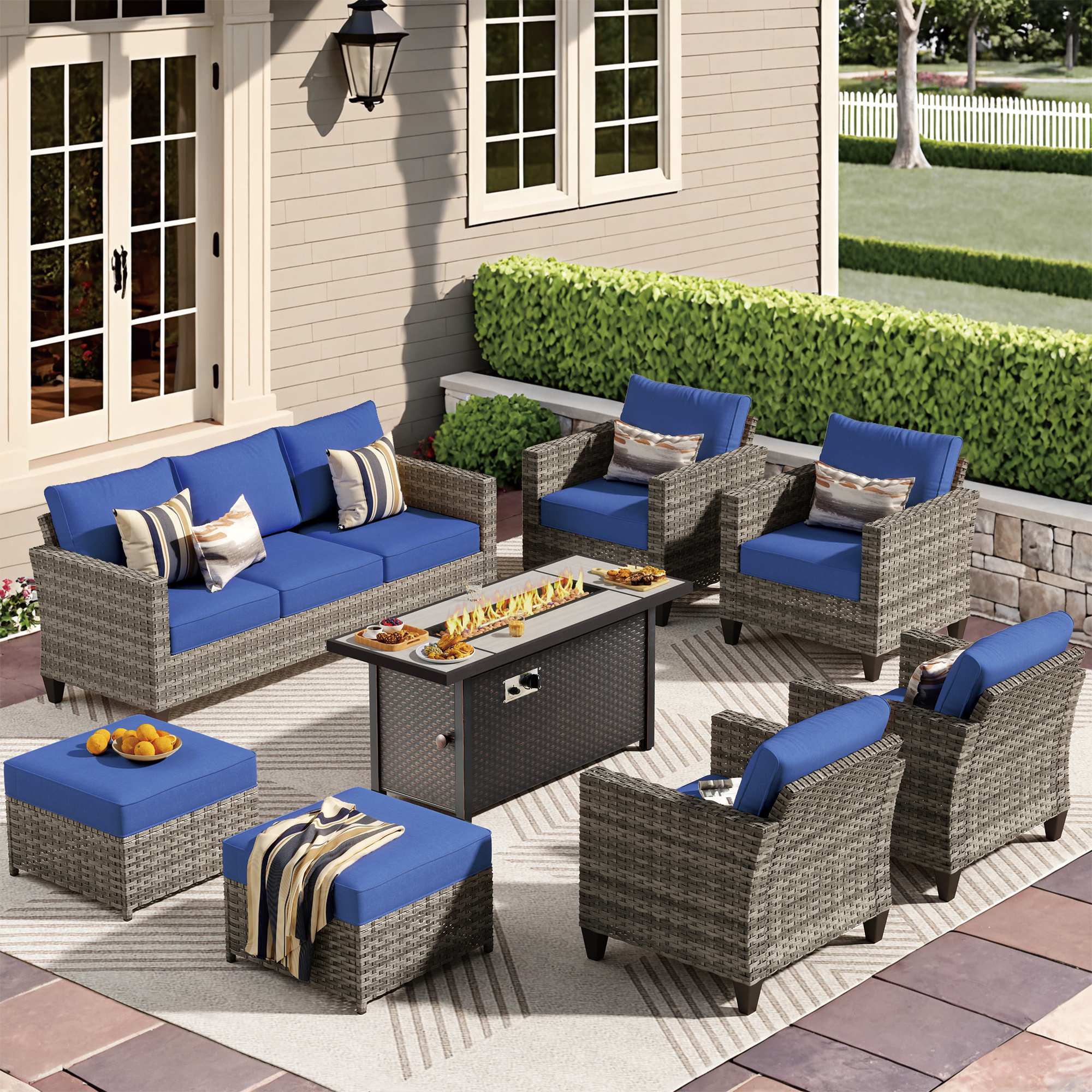 Navy Blue | OVIOS modern wicker patio conversation set with fire pit table, blue sofa, chairs, and ottomans.