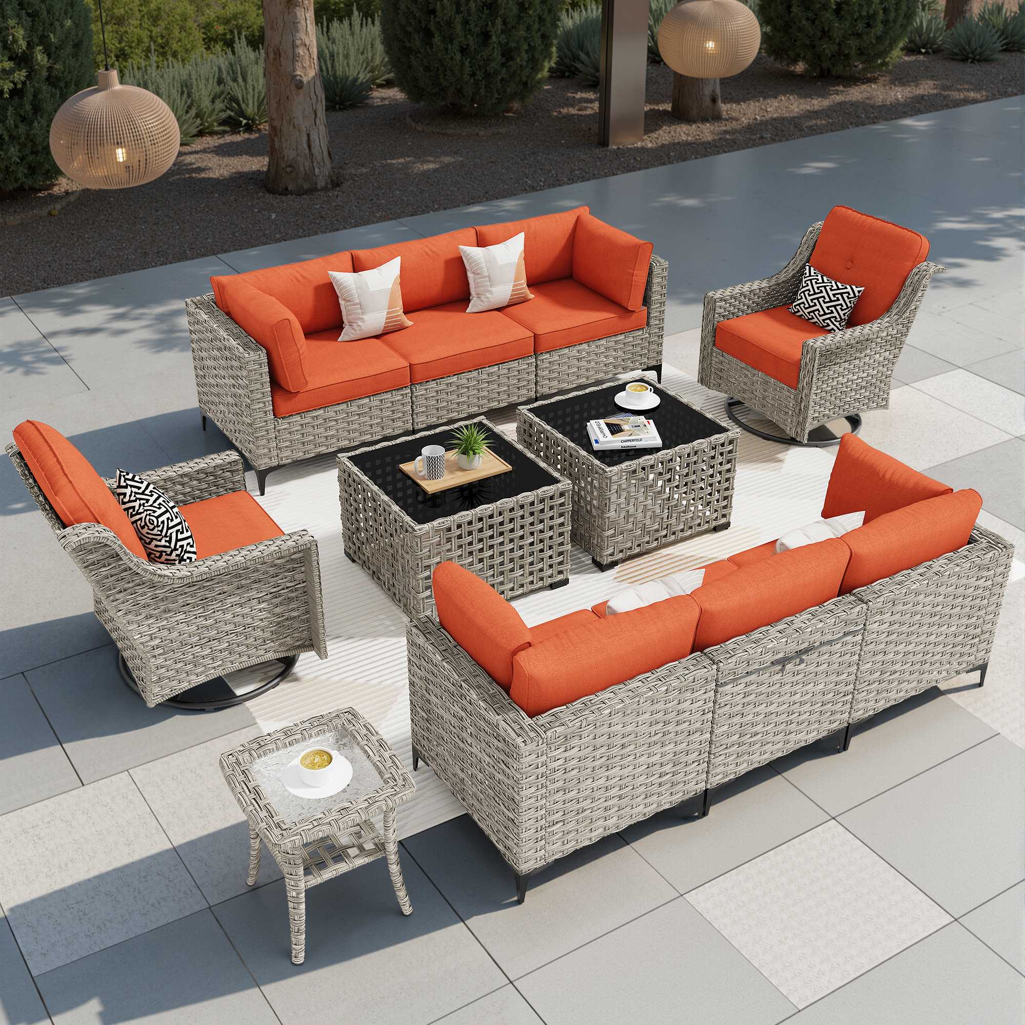 Grey wicker patio conversation set with orange cushions, modular, swivel chair, and solar light table.