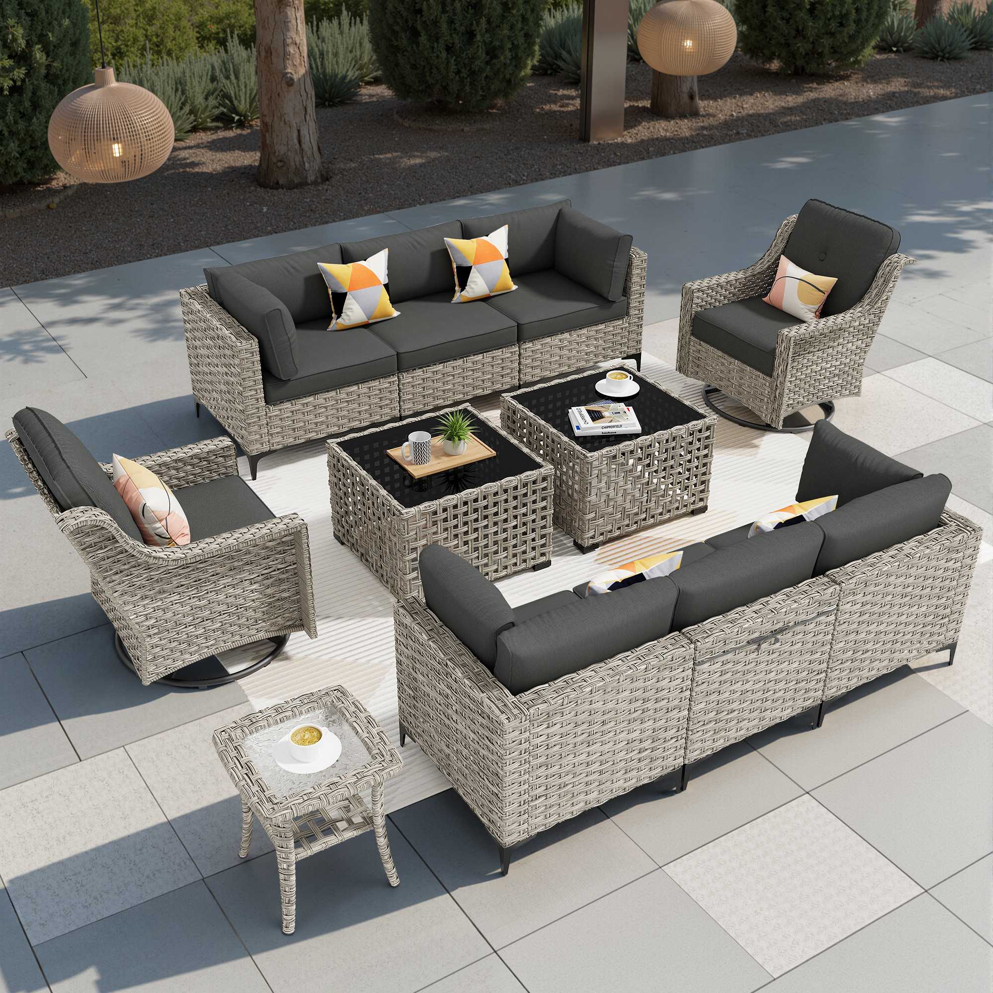 Modular OVIOS outdoor wicker patio conversation set with grey cushions, swivel chair, and glass-top tables.